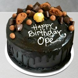 Happy birthday chocolate cake with cookies and chocolates on top